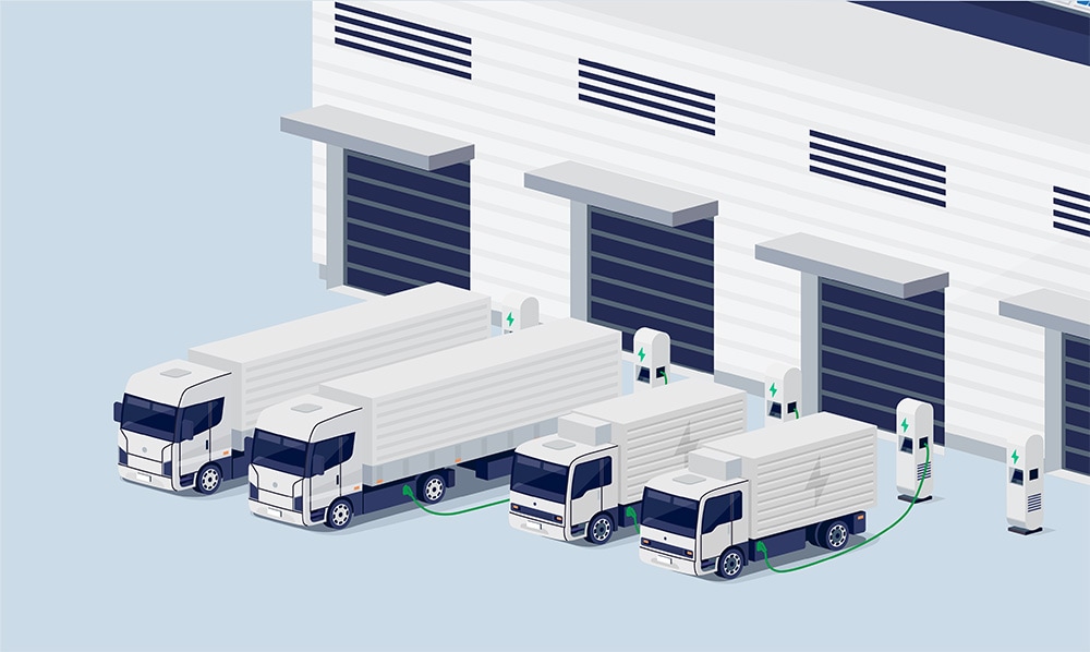 Electric trucks charging outside a loading dock